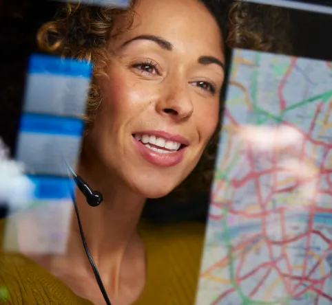 Happy Female Dispatcher looking at a map on the computer screen